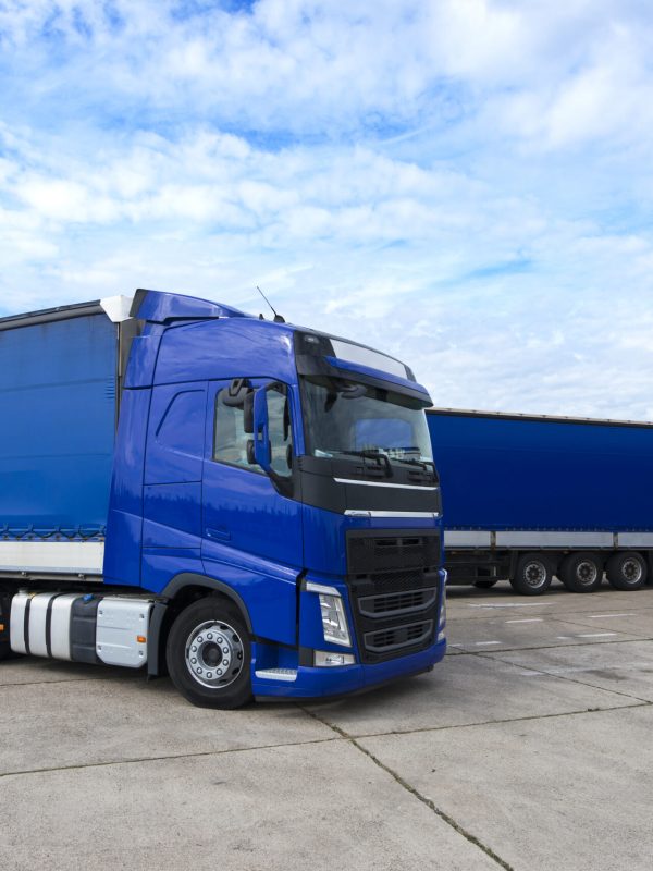 Truck vehicle with trailers in background.